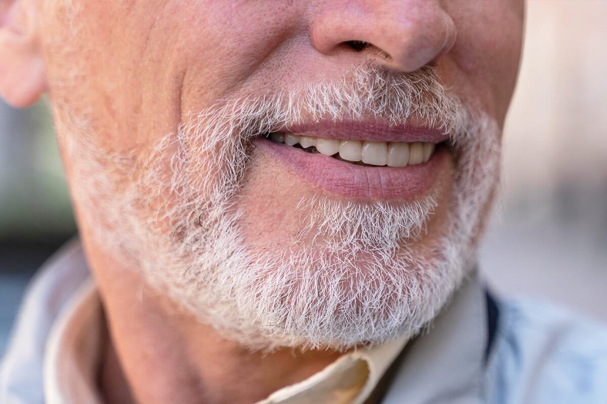 Nahaufnahme eines lächelnden Mannes mit grauem Bart
