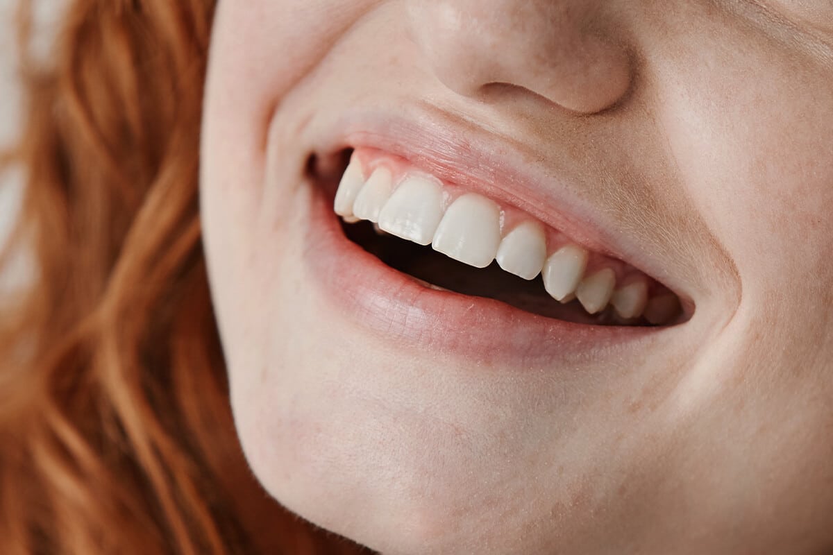 Nahaufnahme einer lächelnden Frau mit gewellten Haaren.